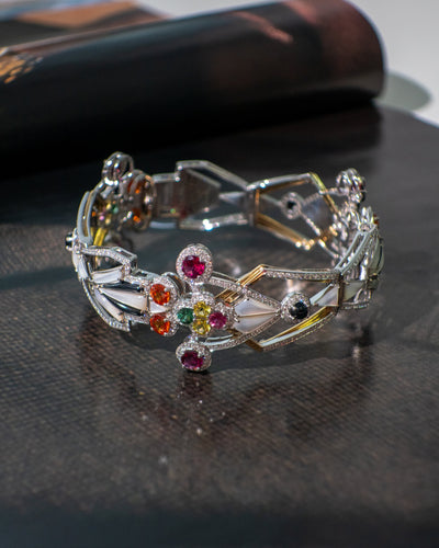 White gold bracelet with colorful gemstones on a dark surface