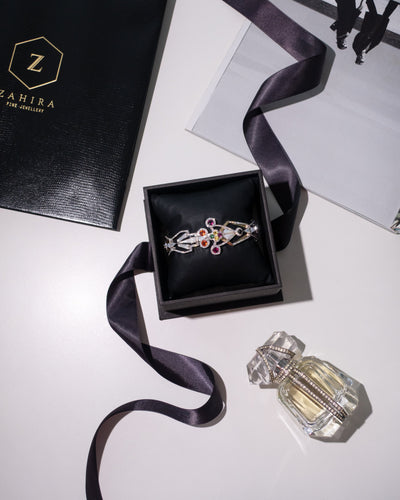 Zahira jewelry box with a gold cuff  on a white surface.